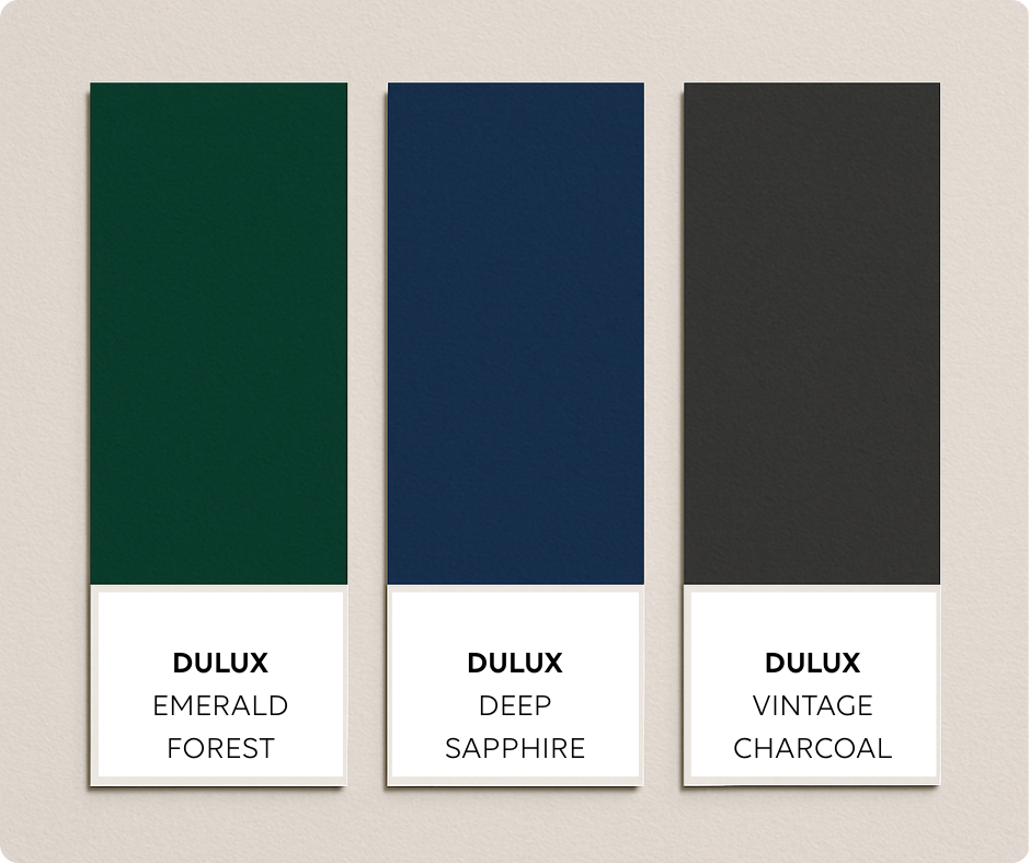 Three Dulux swatches are displayed vertically on a light neutral background. The colours shown are Deep Emerald (dark green), Majestic Blue (navy), and Moody Charcoal (dark grey), each with labels beneath the colour blocks.